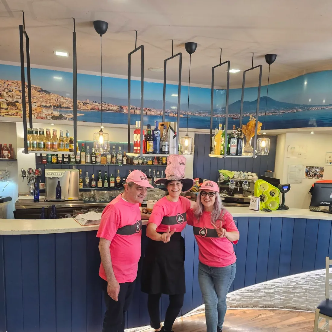 Il bancone bar sotto il murale del golfo di Napoli